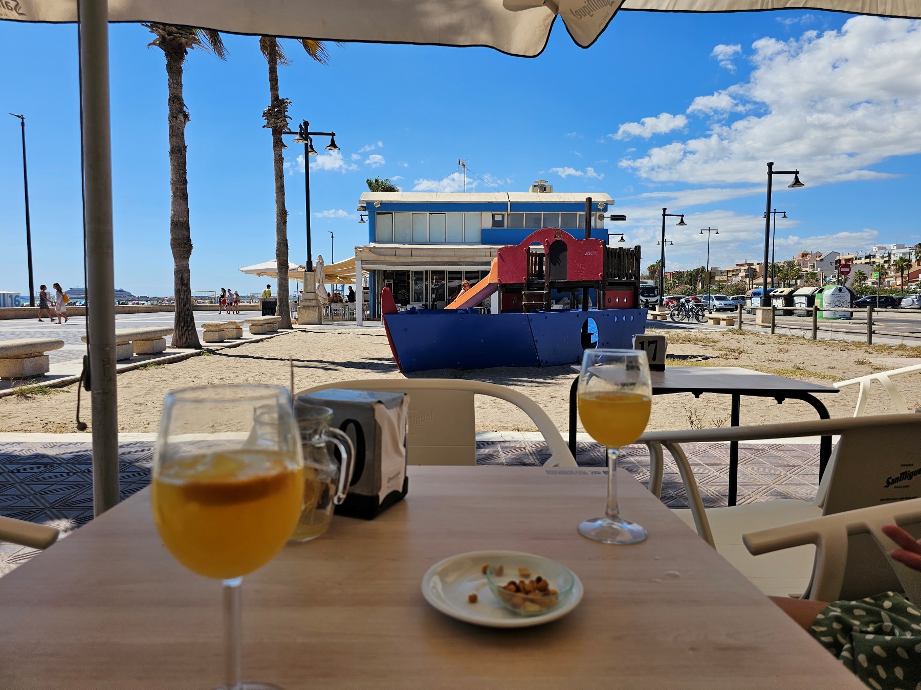 Enjoying Aqua de Valencia drinks on the beach, and next to a playground in Valencia, Spain