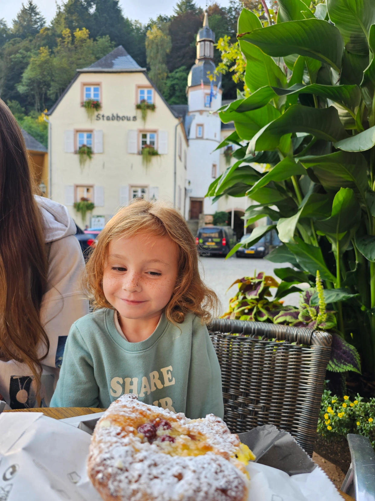 Millie enjoying breakfast pastry outside of Vianden Castle in Luxembourg